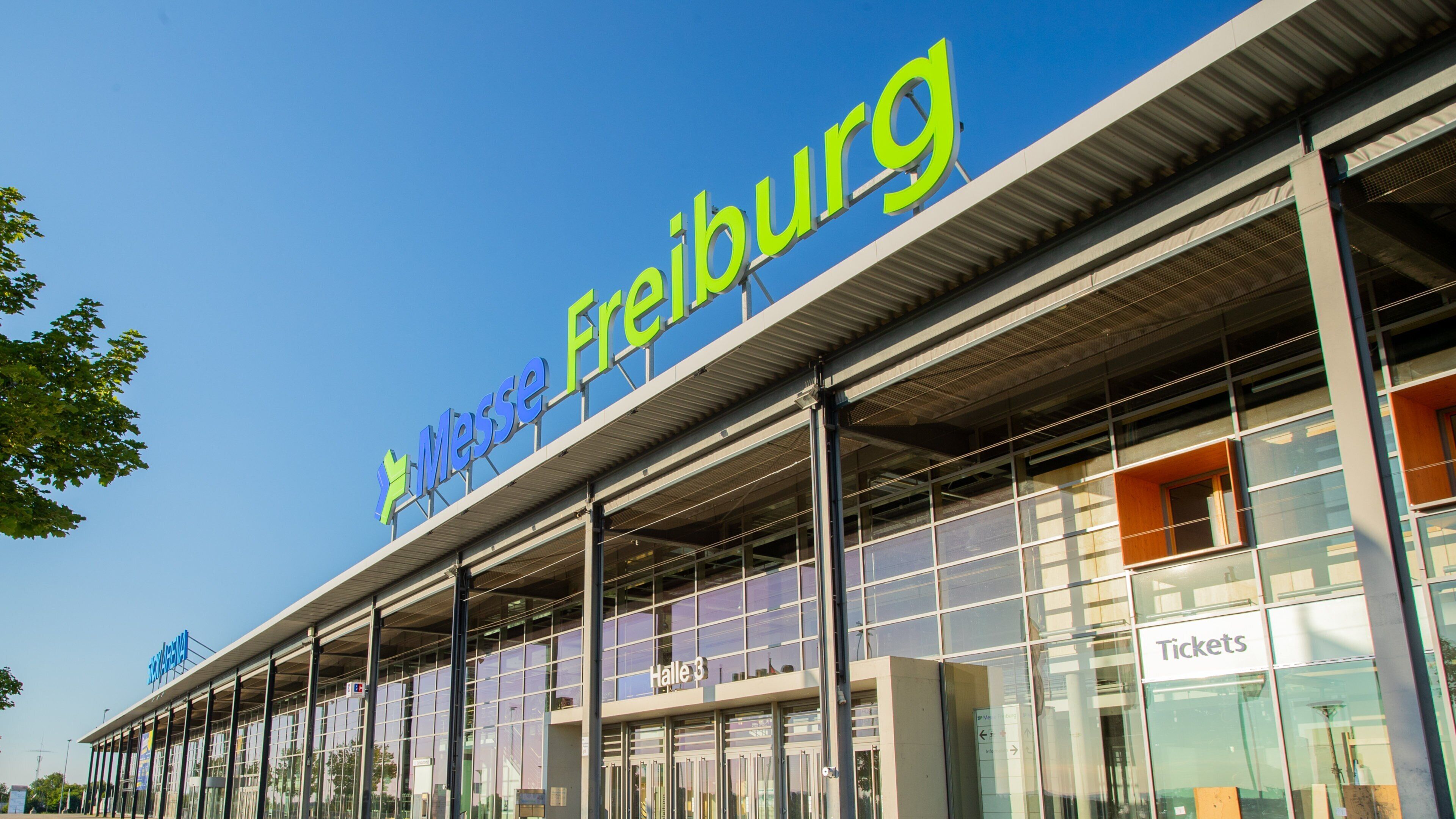 A modern building with a large sign reading "Messe Freiburg".