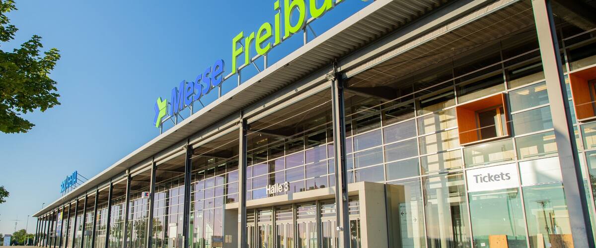 A modern building with a large sign reading "Messe Freiburg".