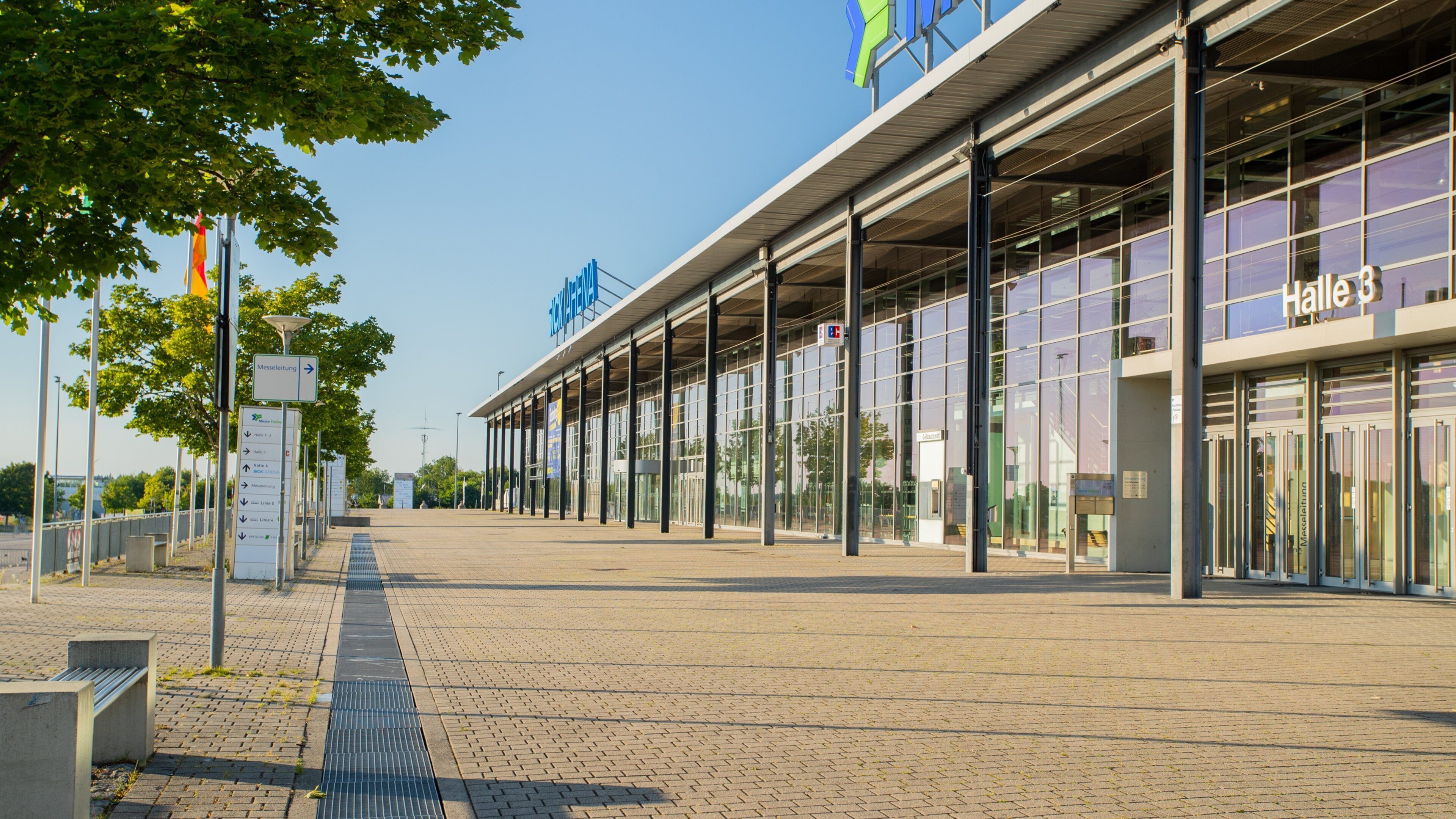 A modern train station with glass windows and a clear sky.