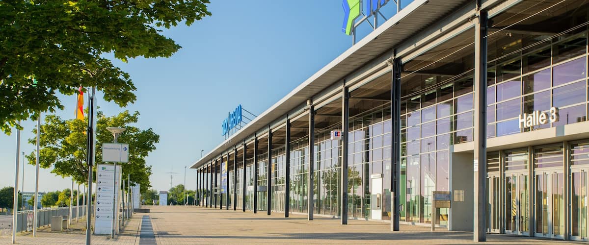 A modern train station with glass windows and a clear sky.