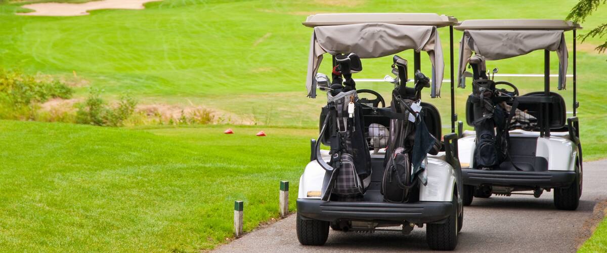 Two golf carts over beautiful green.