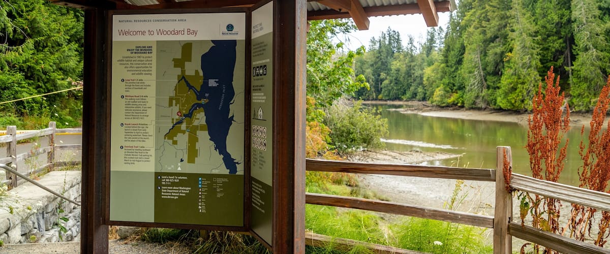 Woodard Bay Natural Resources Conservation Area which includes a river or creek and signage