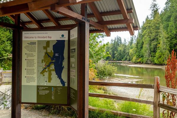 Woodard Bay Natural Resources Conservation Area which includes a river or creek and signage