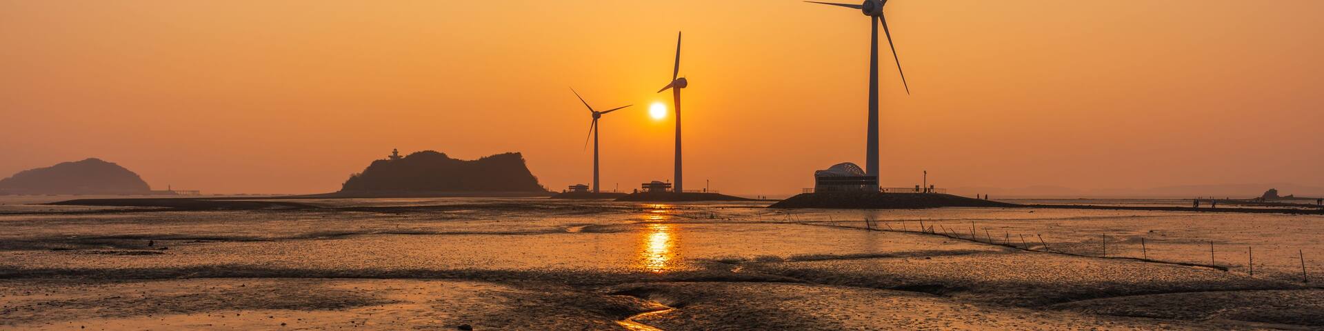 Beautiful sunset over wind turbines on a tidal flat at low tide near Tando Port in Ansan, South Korea