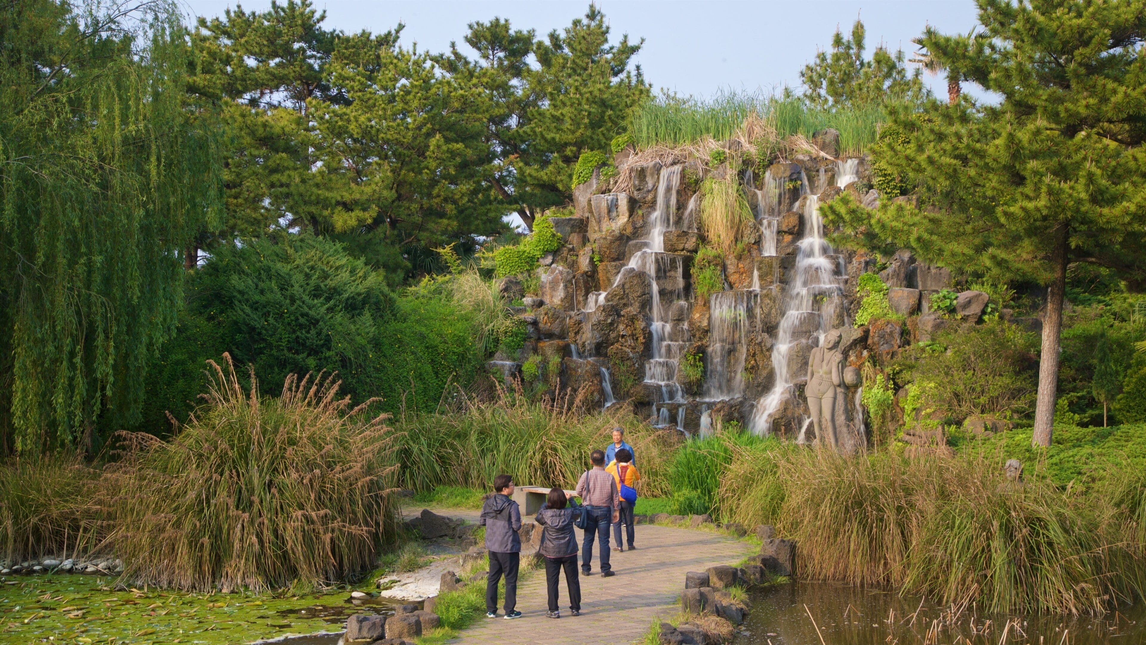 Hallim featuring a garden and a cascade as well as a small group of people