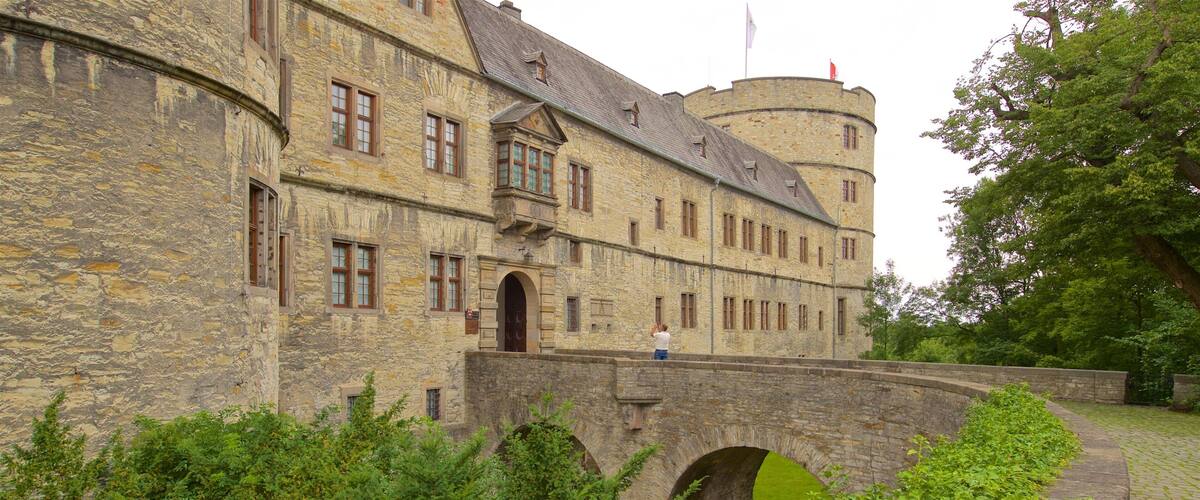 A historic stone building with a turret and a bridge.