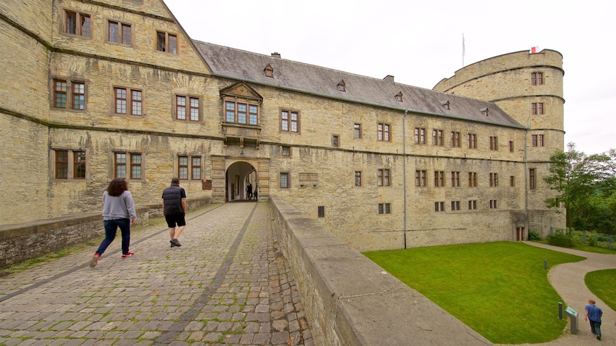 Ein historisches Steinhaus mit Innenhof und einer Flagge auf dem Dach.