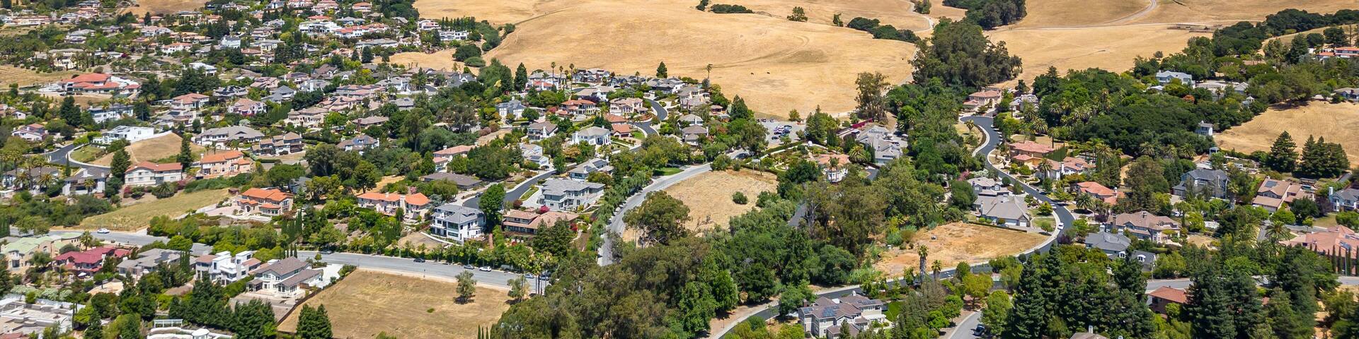 Drone photo of Mission Peak in Fremont, California on a beautiful summer day, with dead hills and houses at the base of the mountain.