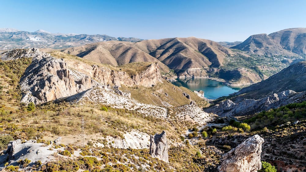 A mountainous landscape with a valley and a lake.