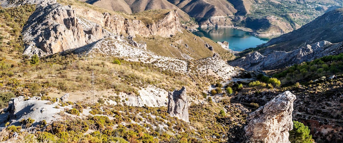 A mountainous landscape with a valley and a lake.