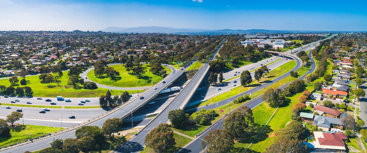 Wide aerial panorama of highway interchange on sunny day