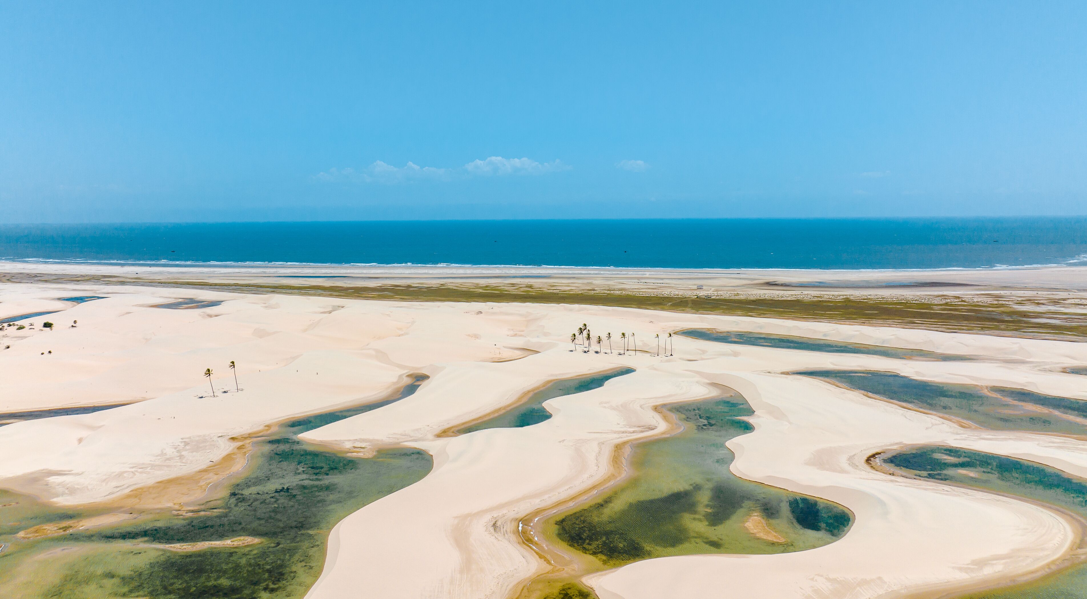 A desert landscape with sand dunes and a body of water.