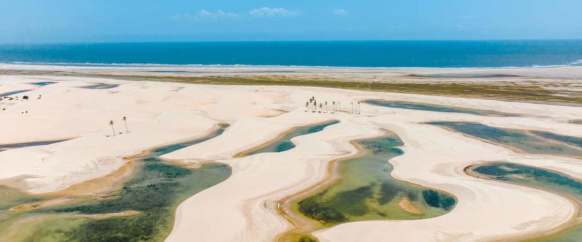 A desert landscape with sand dunes and a body of water.