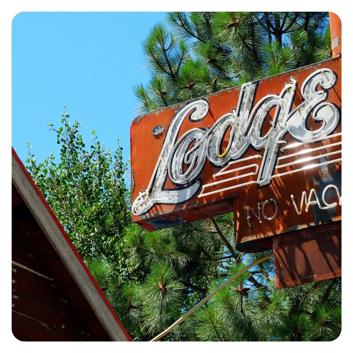A vintage sign with the name 'Lodge' and 'No Vac' partially visible.