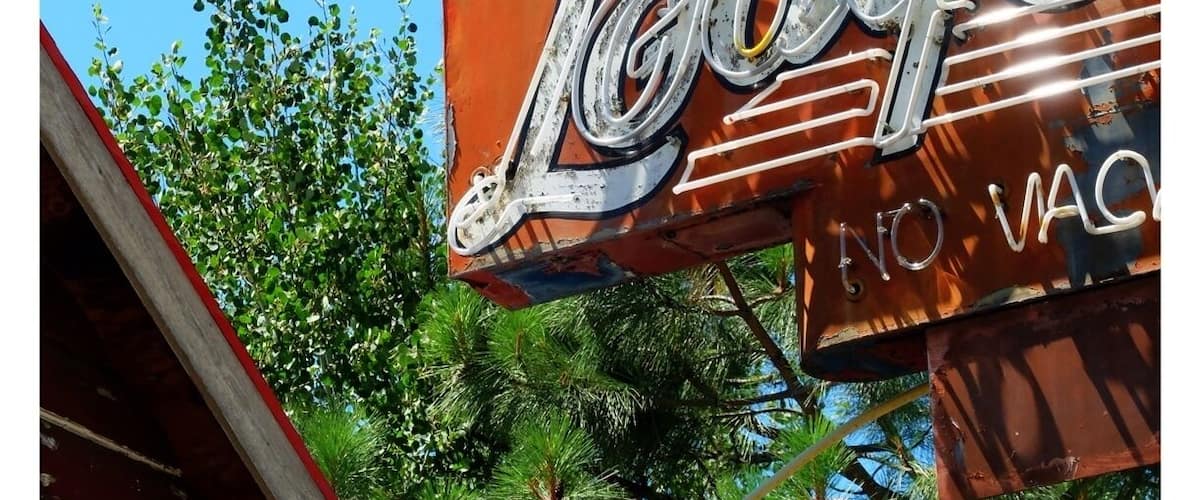A vintage sign with the name 'Lodge' and 'No Vac' partially visible.