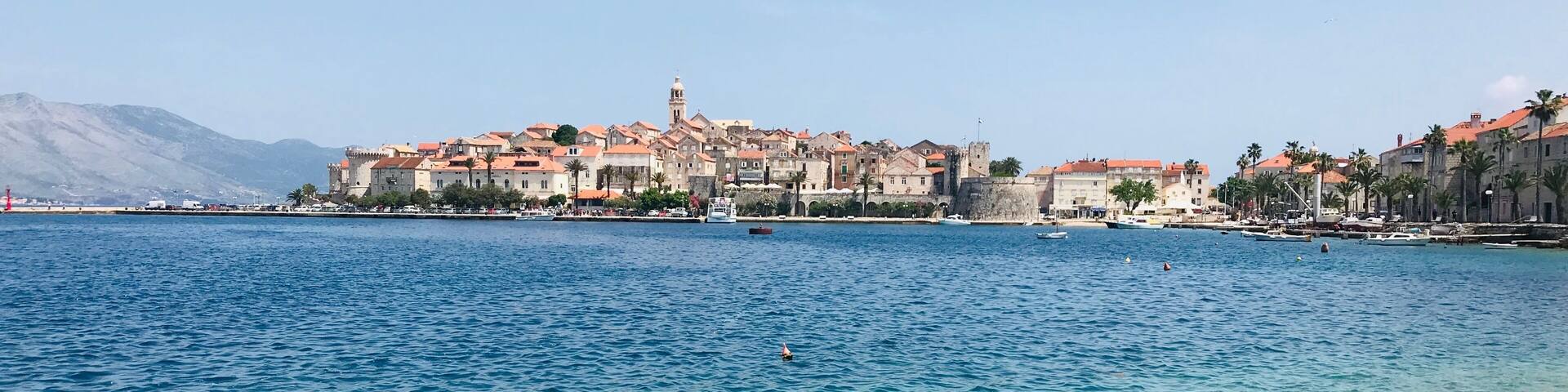 A coastal town with historic buildings and a clear blue sea.