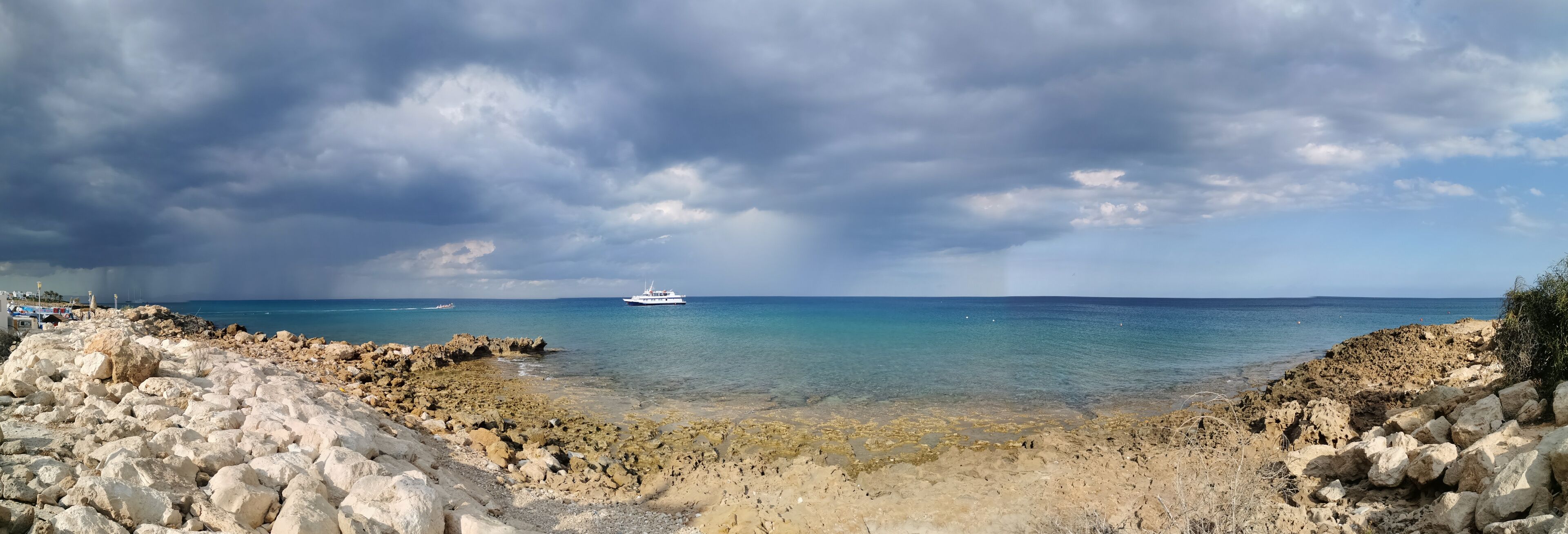 A rocky coastline with a boat in the distance.