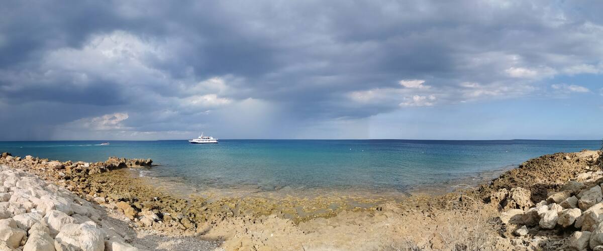 A rocky coastline with a boat in the distance.
