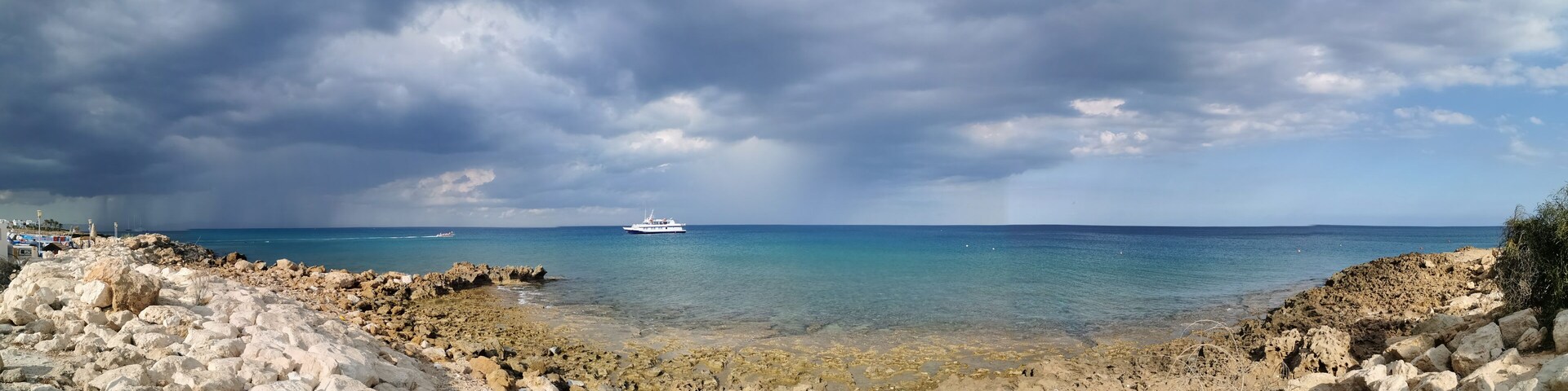 A rocky coastline with a boat in the distance.