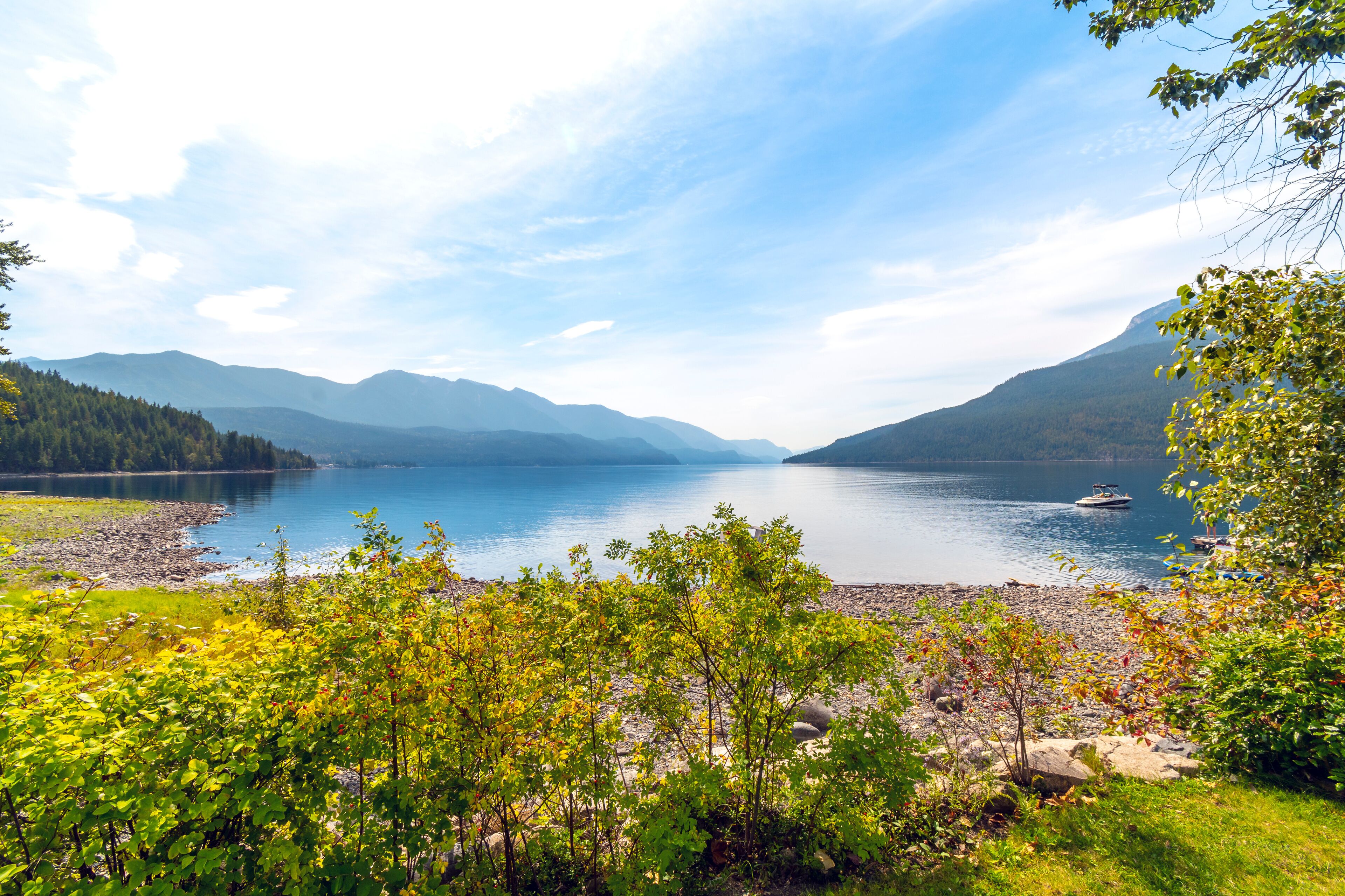 Um lago rodeado por montanhas e árvores.