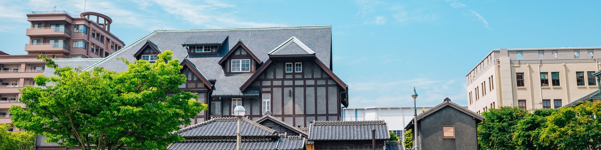 Il s’agit d’un bâtiment japonais traditionnel, doté d’un toit en pente et d’une façade en bois, entouré d’un jardin bien entretenu et bordé d’un chemin pavé.