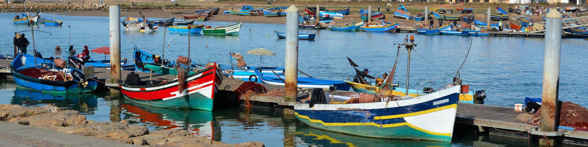 Rabat, Morocco - December 26, 2015: New exclusive apartment buildings at Bouregreg Marina in Rabat. Traditional blue fishing boats in the foreground.