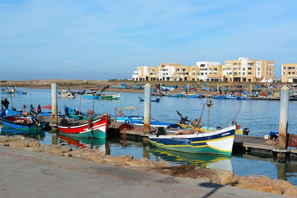 Rabat, Morocco - December 26, 2015: New exclusive apartment buildings at Bouregreg Marina in Rabat. Traditional blue fishing boats in the foreground.