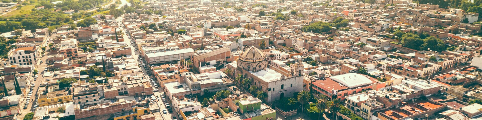 Vista aérea de una ciudad densamente poblada con una mezquita destacada y el paisaje urbano circundante.