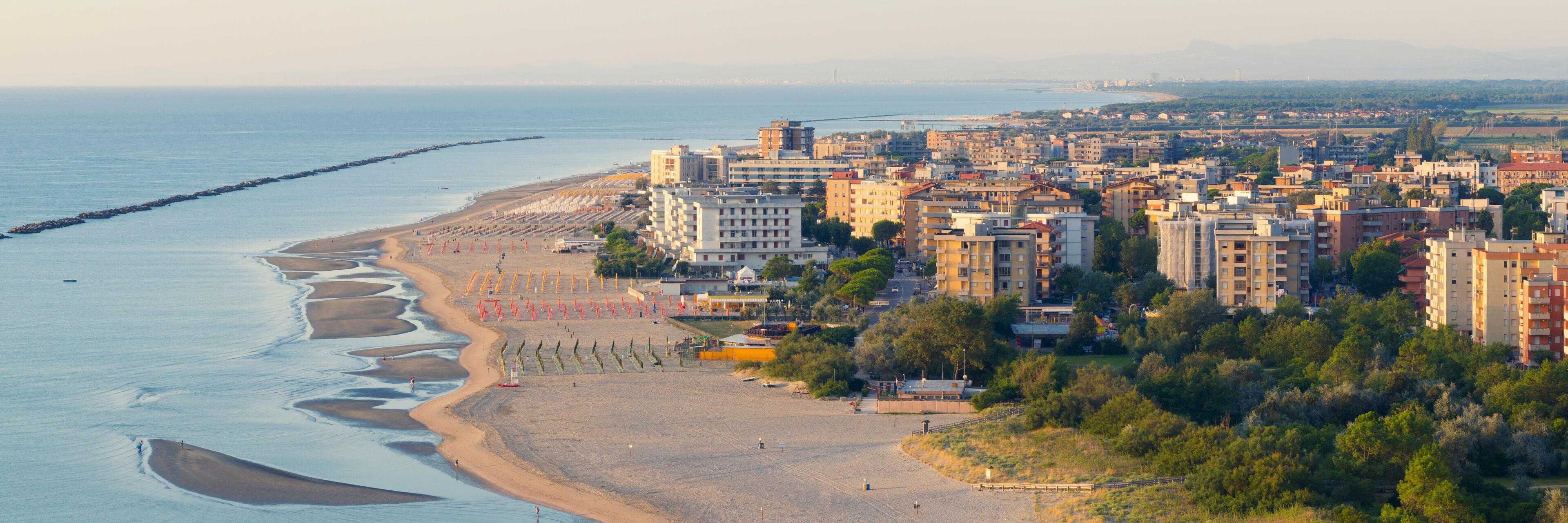 Drone view of sandy beach with umbrellas and gazebos.Summer vacation concept.Lido Adriano town,Adriatic coast, Emilia Romagna,Italy.