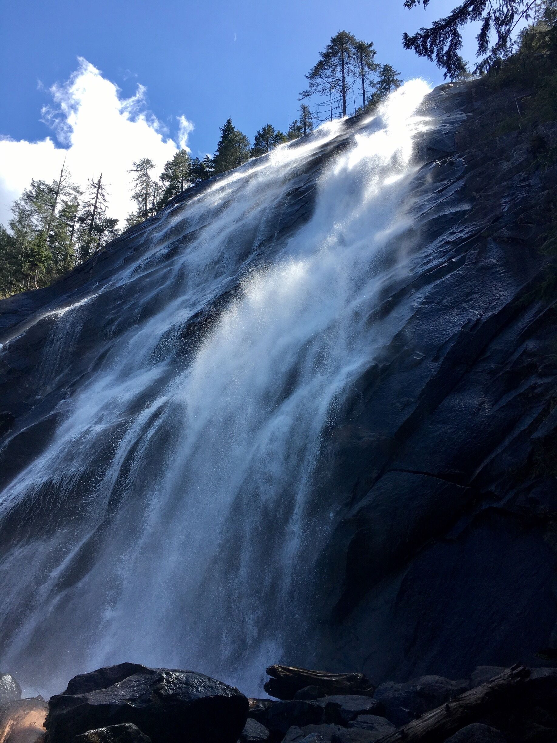 A waterfall cascading down a rocky slope surrounded by trees.