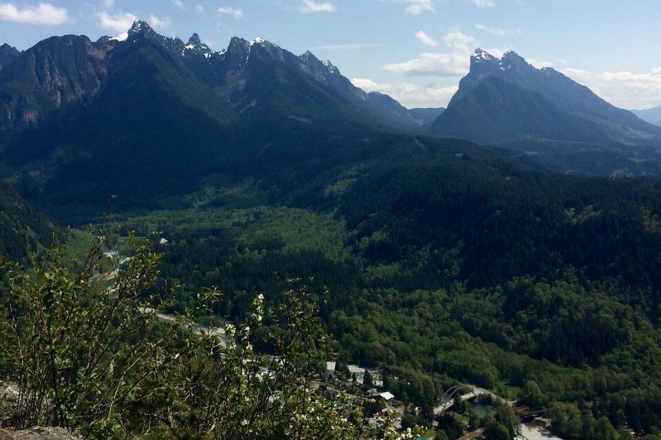 Paisagem montanhosa com um rio e um pequeno povoado.