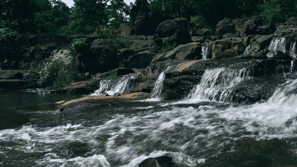 A waterfall cascading over rocks in a forested area.