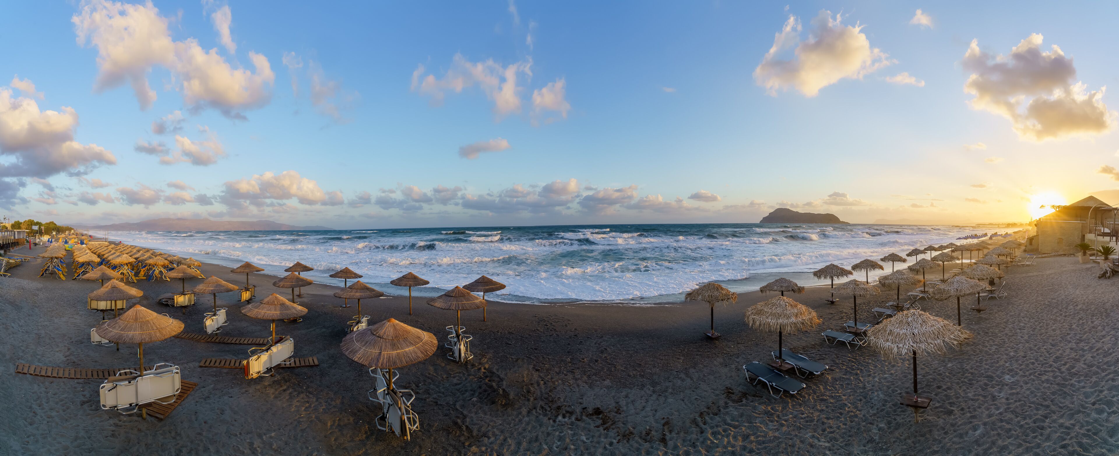 A beach with umbrellas and lounge chairs.