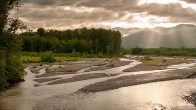 Nooksack River Sunrise. Light rays streaking across the North Cascade Mountains during a lovely sumertime sunrise.