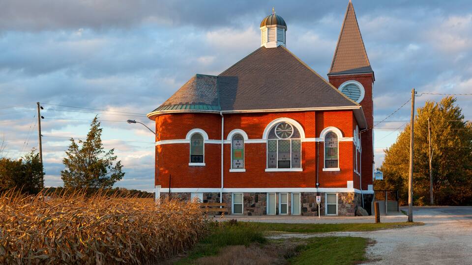 A red brick church with a steeple and a clock tower.