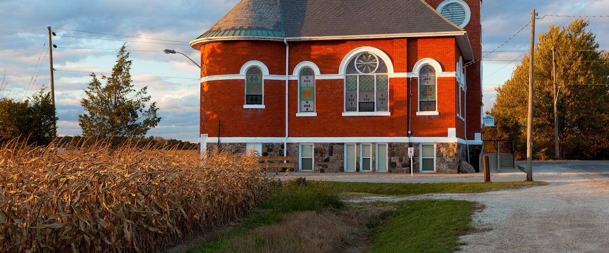 A red brick church with a steeple and a clock tower.