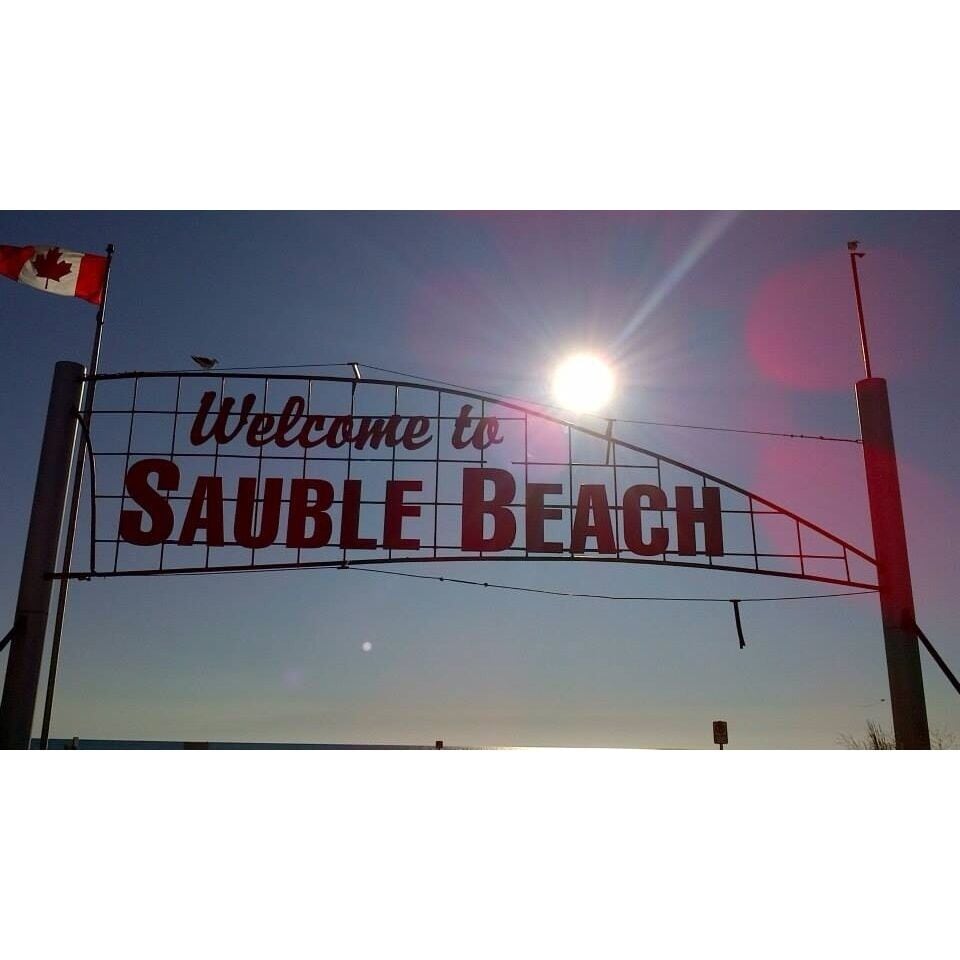 A welcome sign to SAUBLE BEACH with the Canadian flag.
