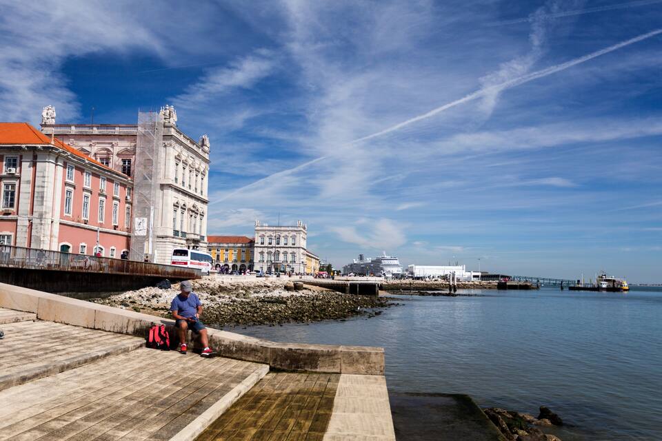 Una passeggiata lungomare con edifici storici, un ponte e una nave da crociera.