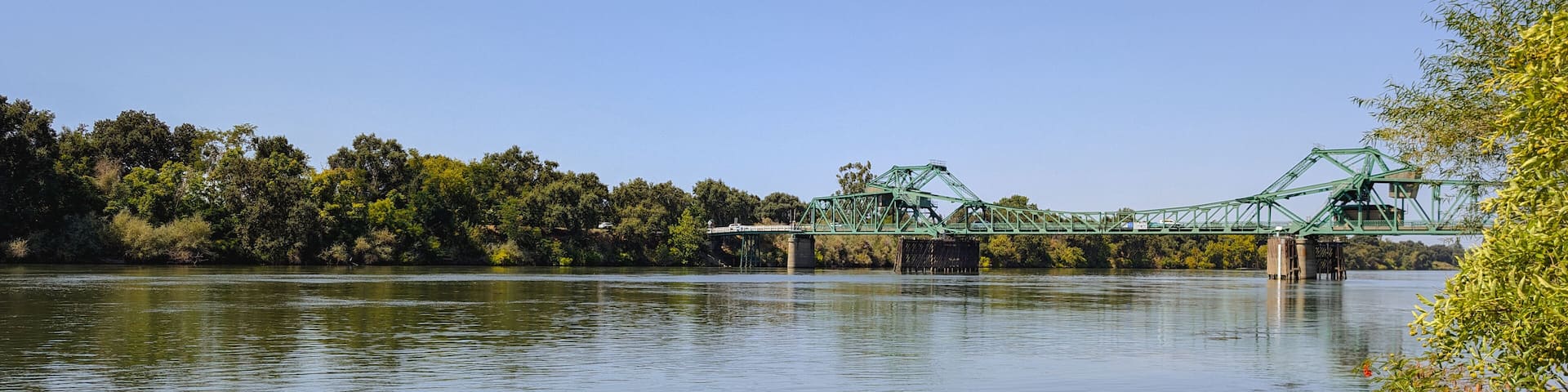 Panorama of a green drawbridge over sacramento river