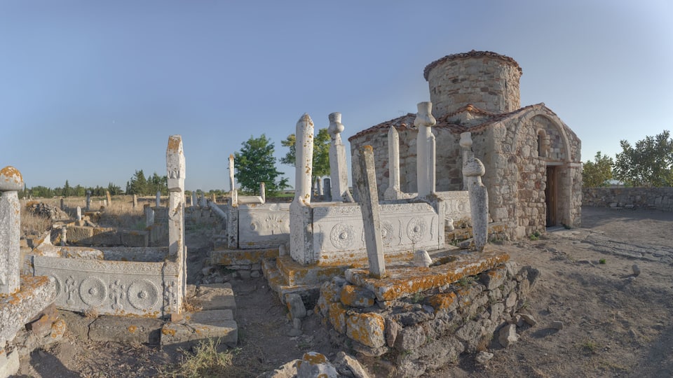 Ancient ruins with columns and a stone building.