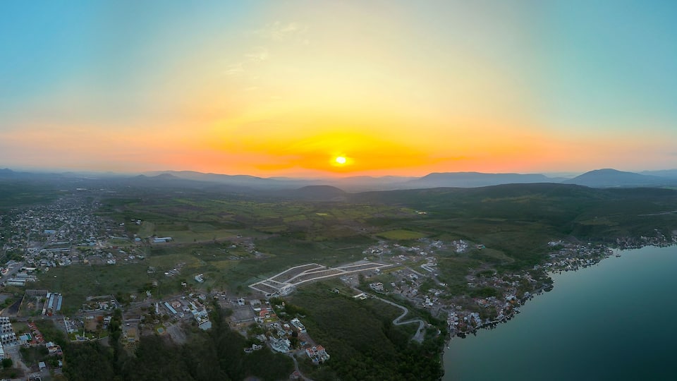 A coastal town with a river, surrounded by hills and mountains.