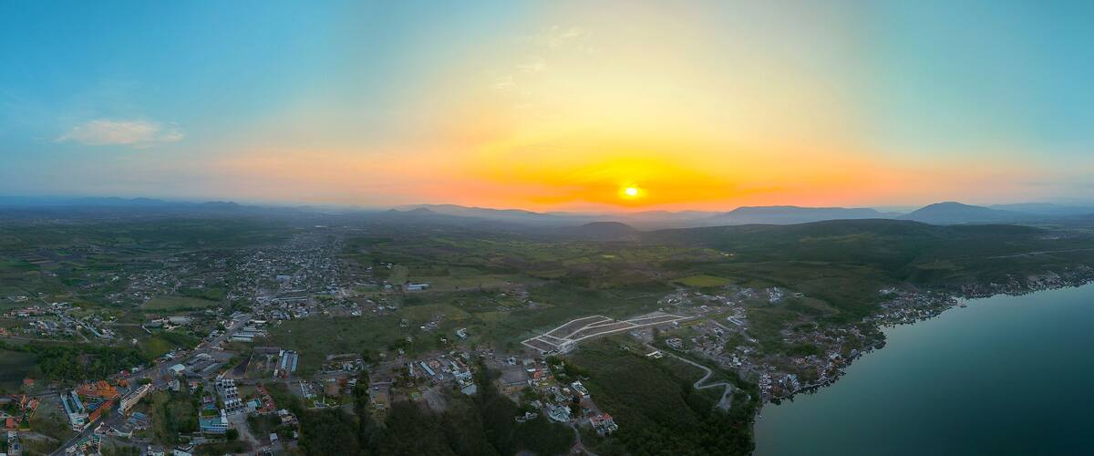 A coastal town with a river, surrounded by hills and mountains.