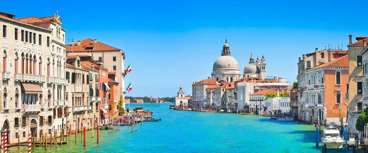 A canal in Venice with historic buildings and the Doge's Palace in the background.