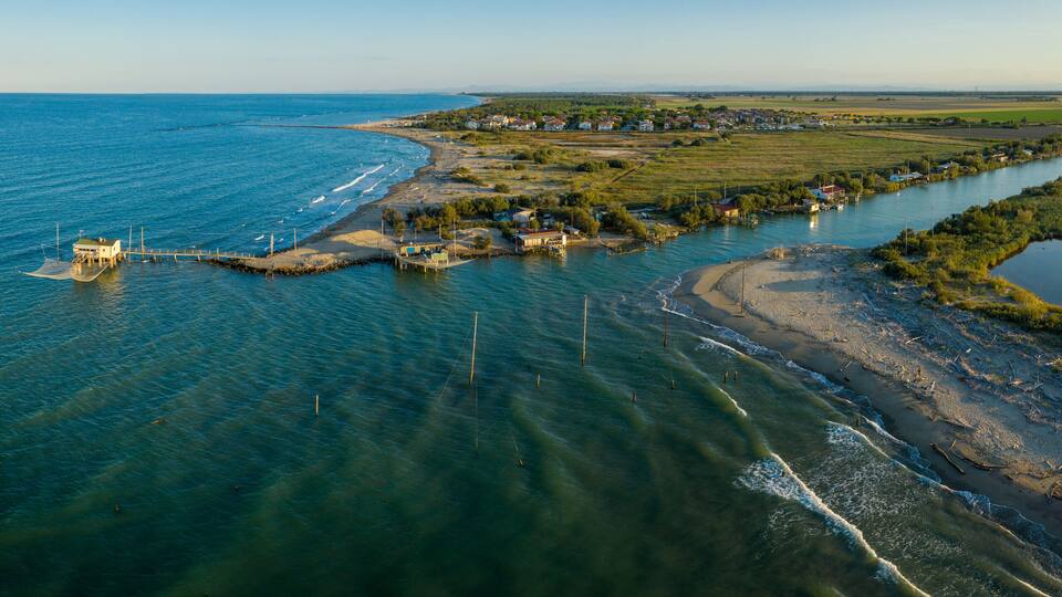 A coastal town with a river, houses, and a pier.