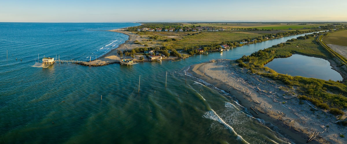 A coastal town with a river, houses, and a pier.
