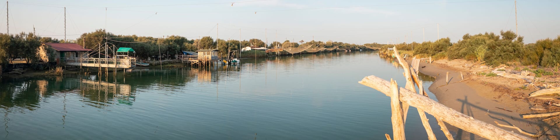Landscape of fishing huts in the river with typical italian fishing machine, called ""trabucco"",Lido di Dante, fiumi uniti Ravenna near Comacchio valley.