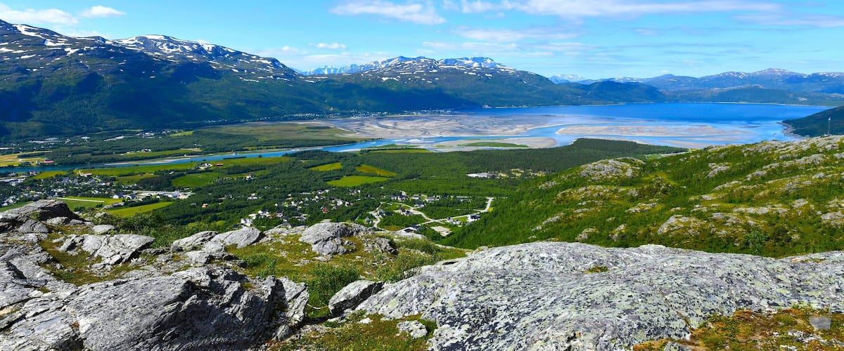 A mountainous landscape with a lake and a small settlement.