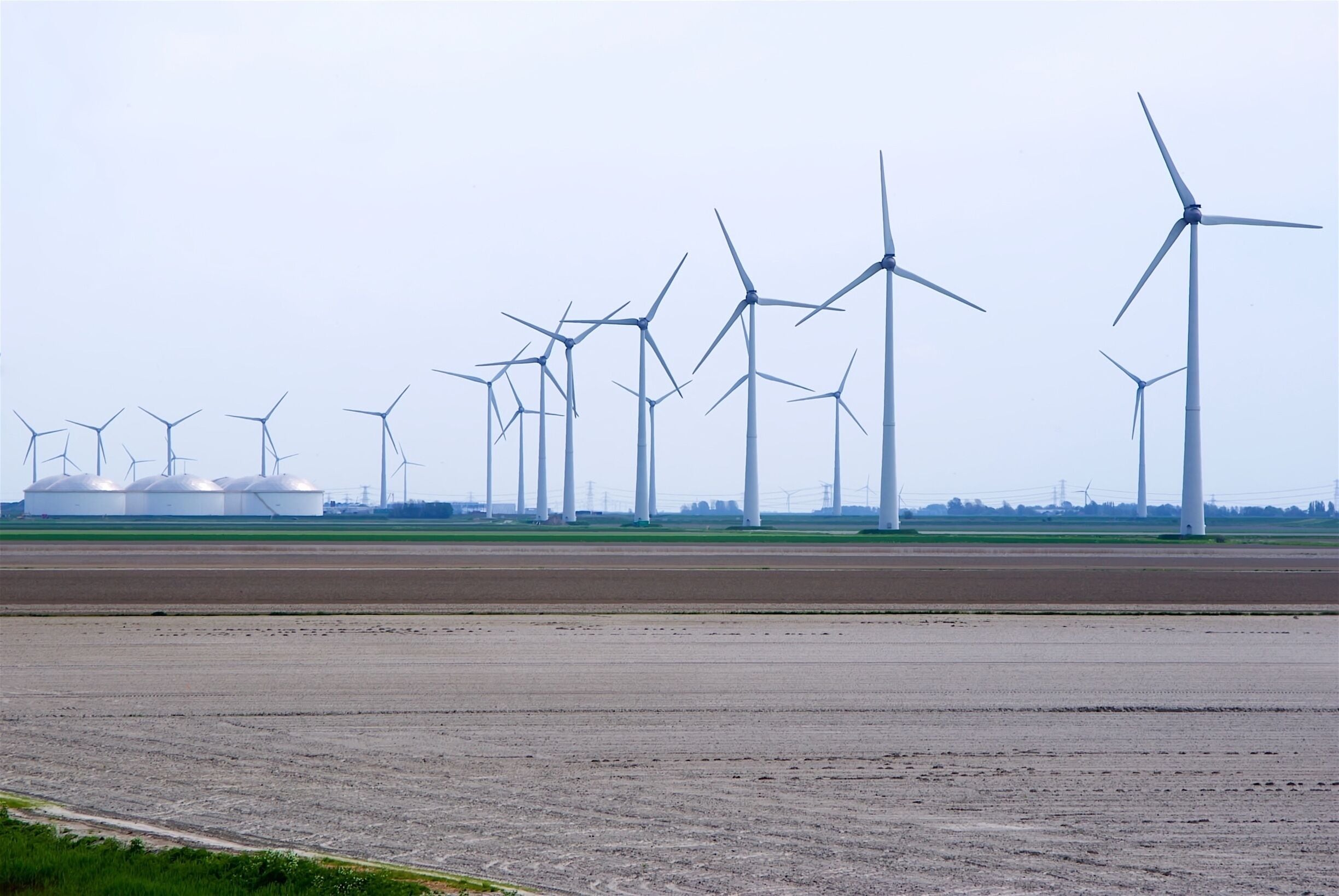 Windmolens in de Eemshaven. Links de opslagtanks van Vopak.