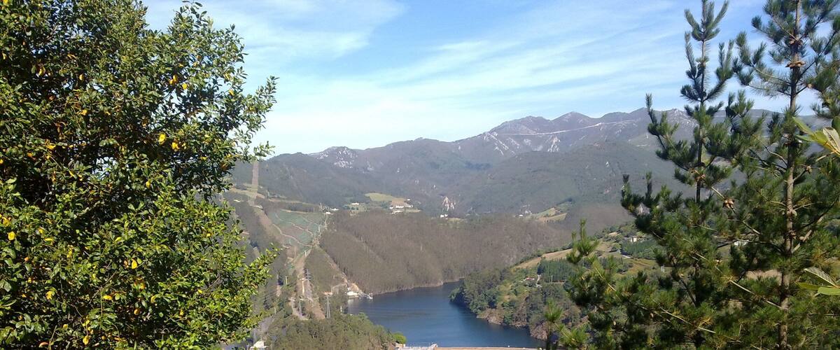 A mountainous landscape with a dam and a lake.