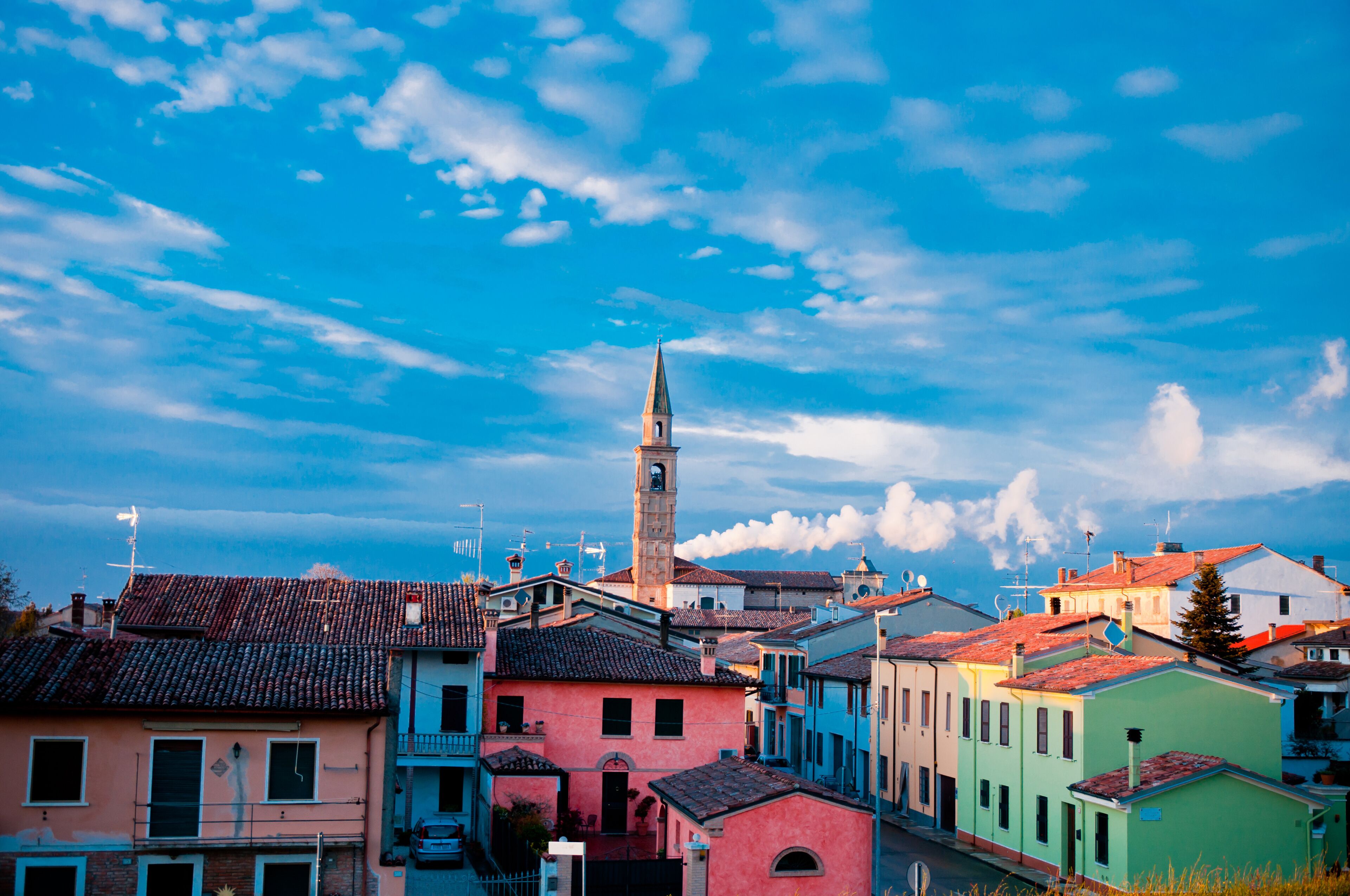 A coastal town with colorful buildings and a prominent church tower.